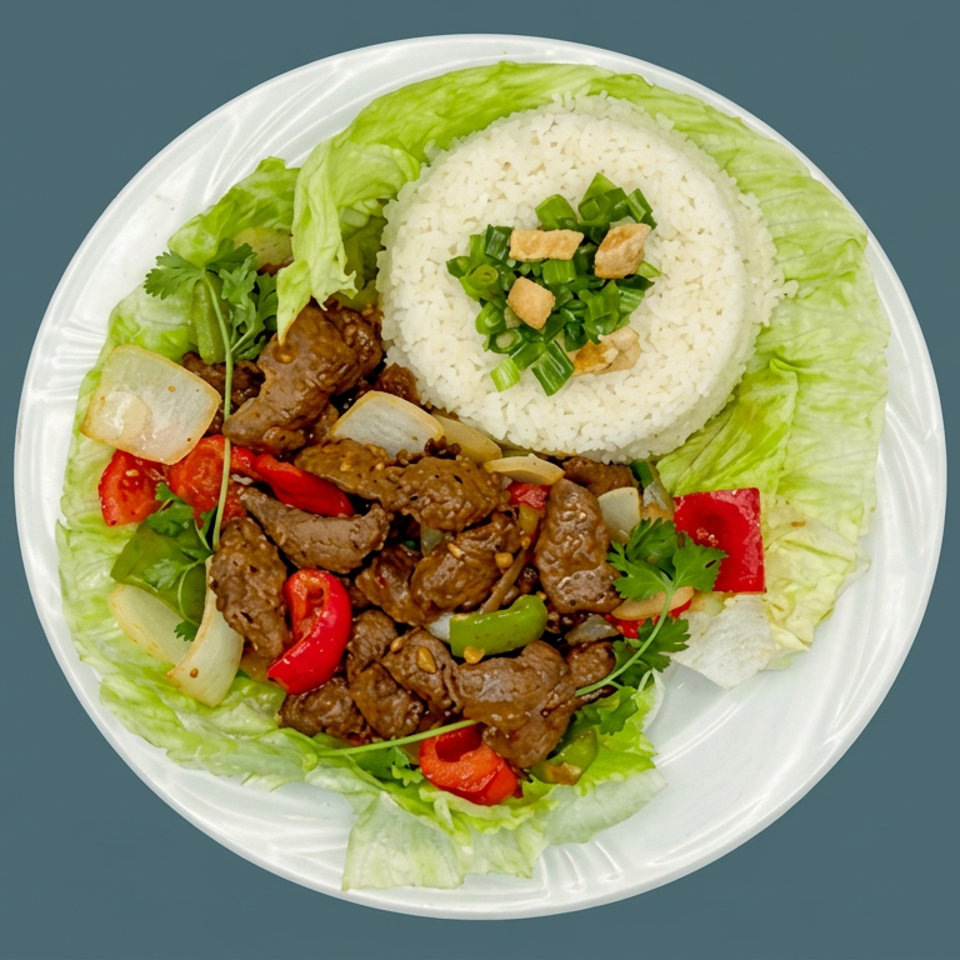 Plate of sautéed beef with onions and peppers, white rice, lettuce, cilantro, and green onions.